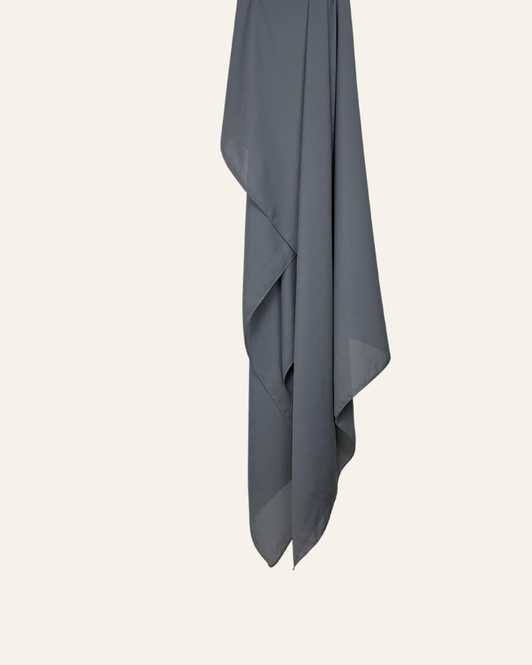 Foulard en crêpe gris brume suspendu sur fond neutre – Maison Maleyka