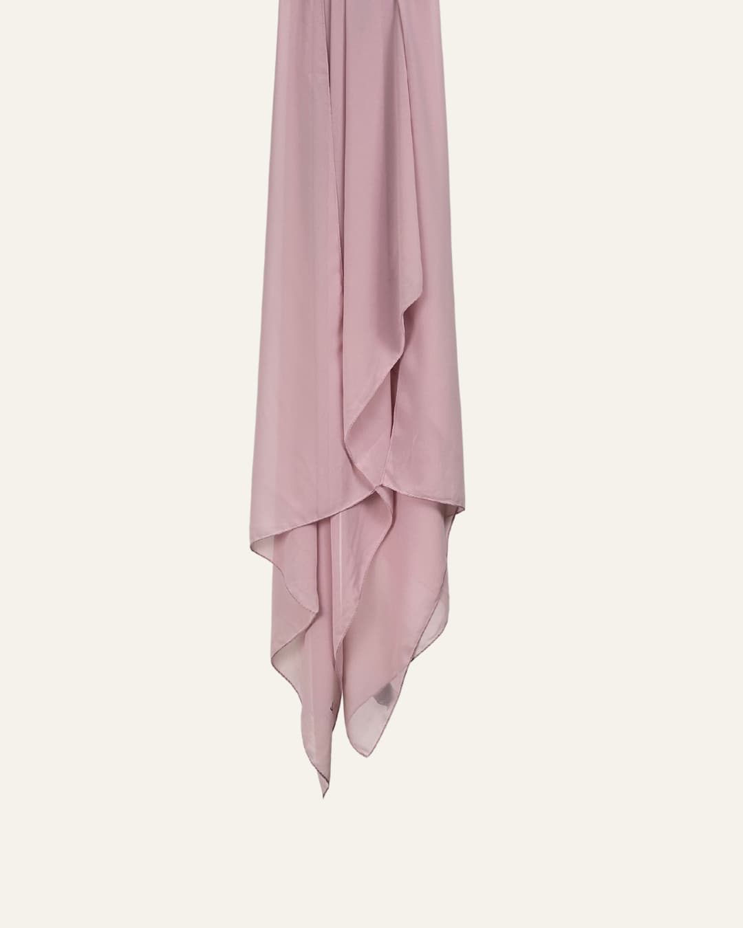 Foulard en mousseline rose pâle suspendu sur fond neutre – Maison Maleyka