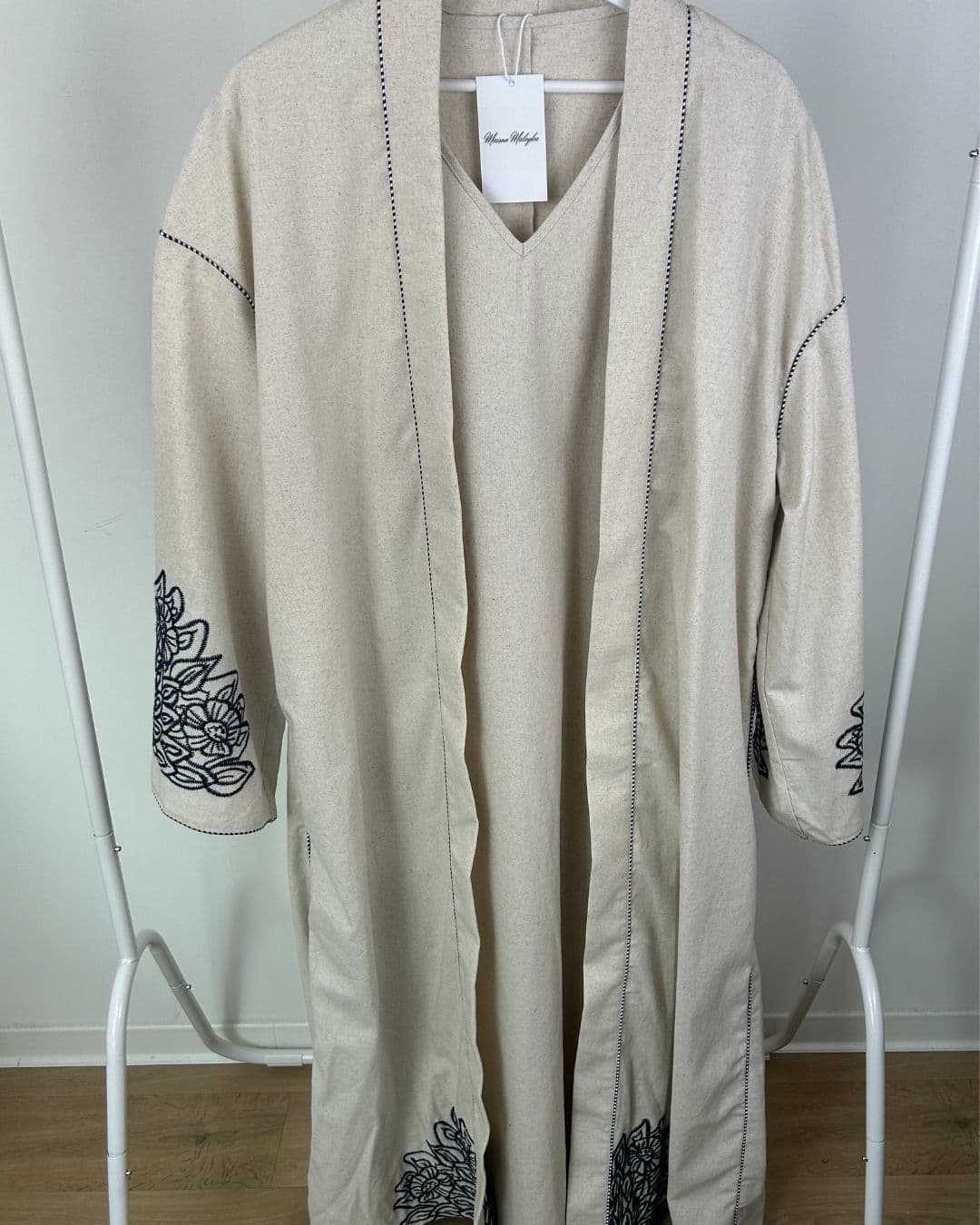 Ensemble abaya 2 pièces écru suspendu sur cintre, avec kimono et robe intérieure