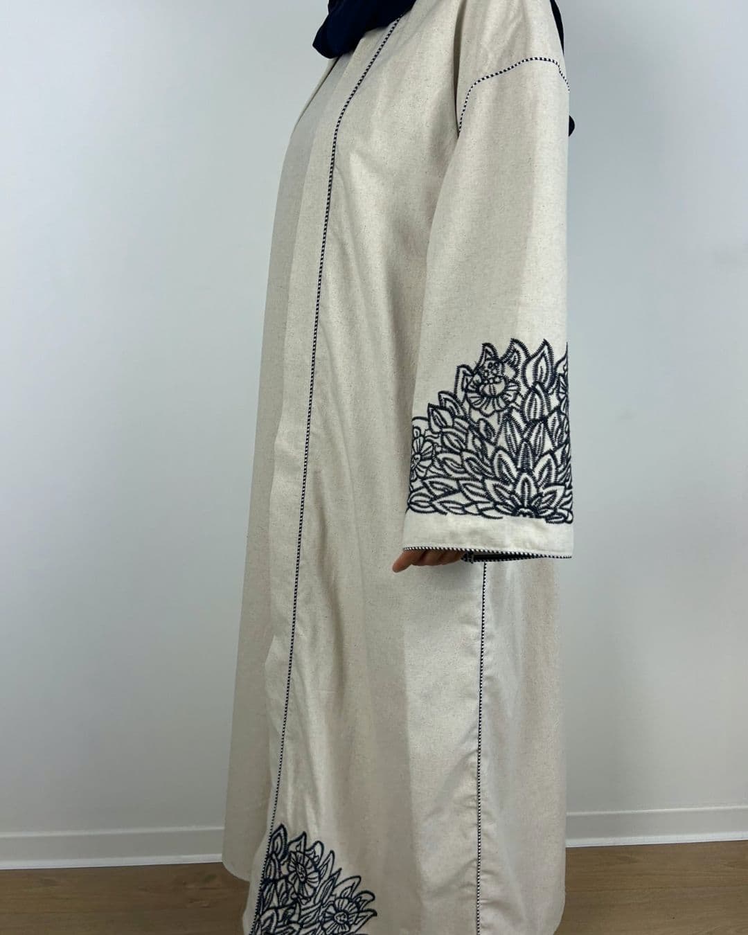 Femme de profil portant une abaya 2 pièces écrue avec kimono brodé
