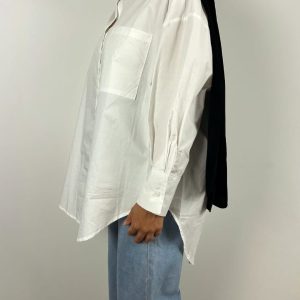 Profil gauche de la chemise oversize blanche portée avec jean