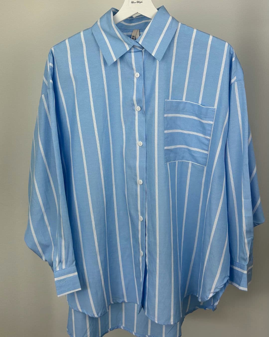 Chemise oversize rayée bleu ciel et blanche sur cintre, vue de face