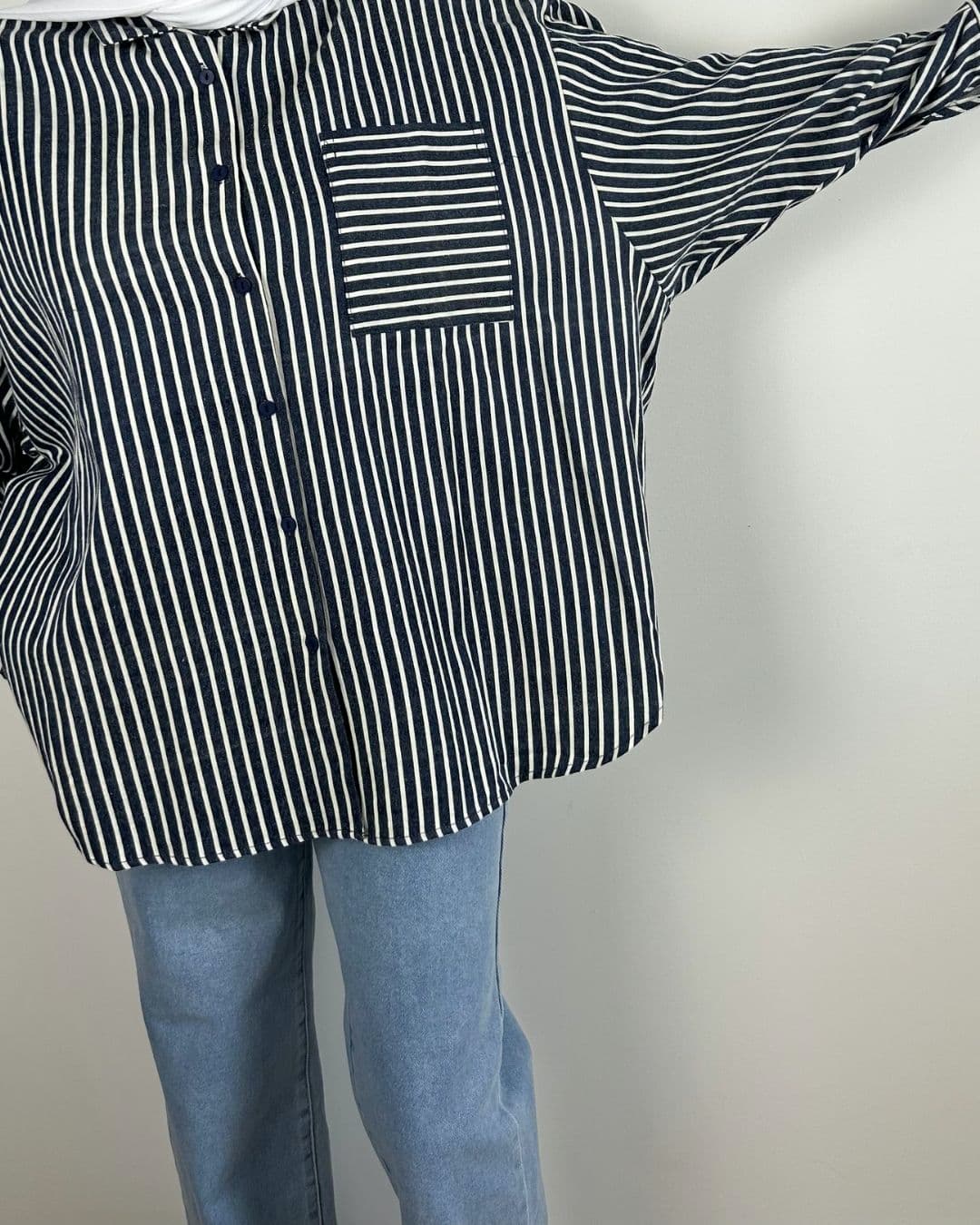 Chemise oversize rayée bleu jean portée, bras tendu
