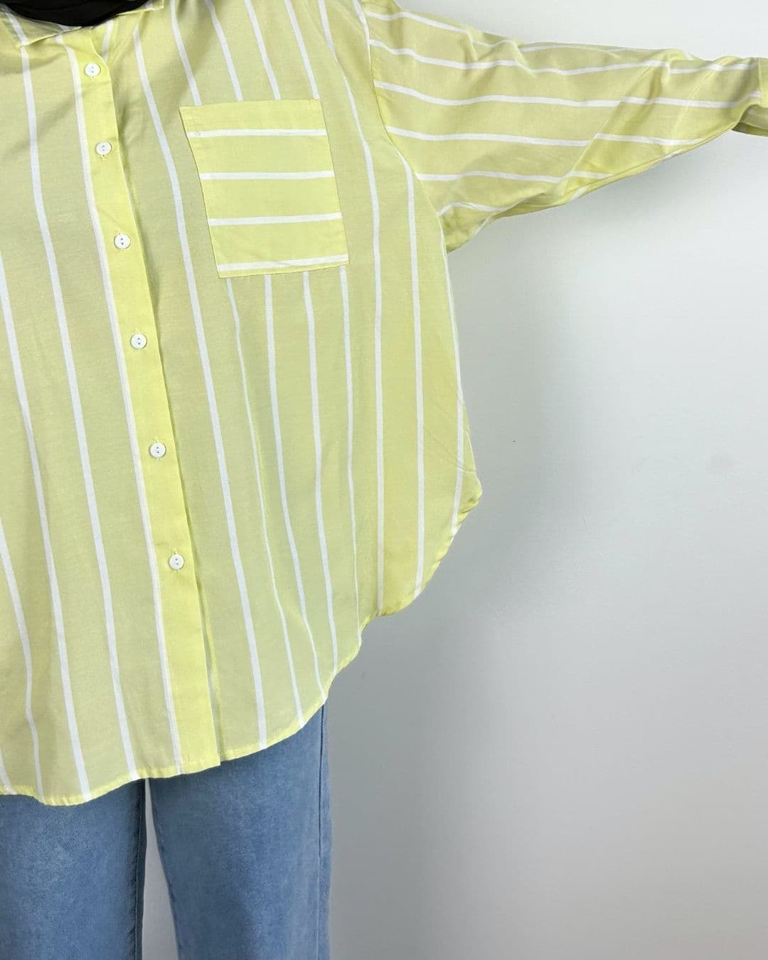Chemise oversize jaune pastel portée, bras gauche tendu