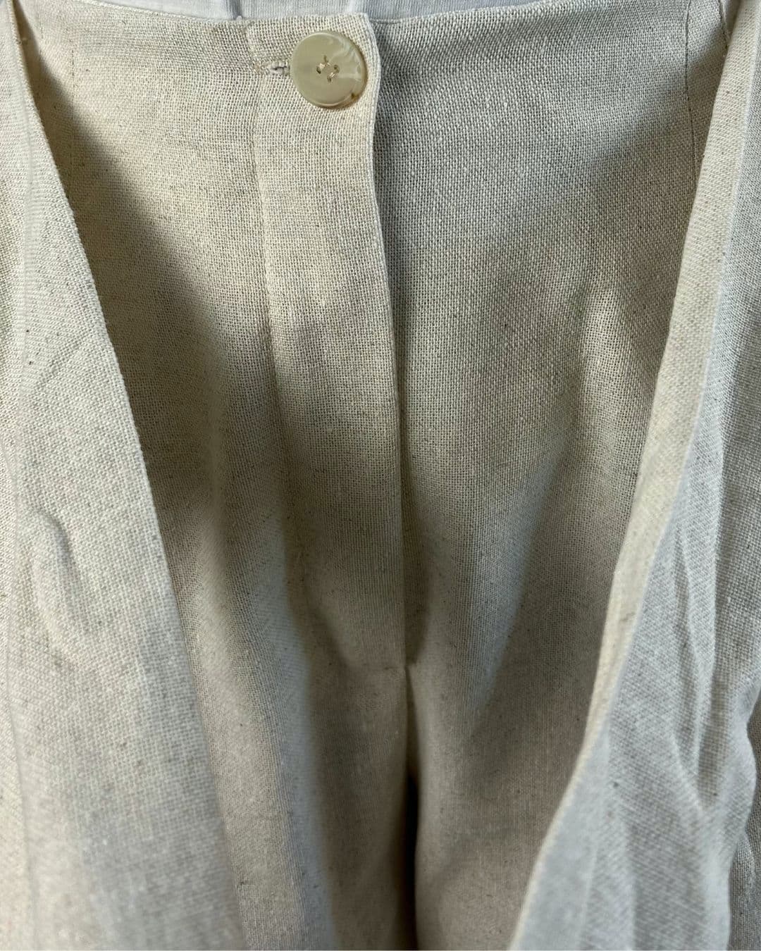 Détail du bouton sur un pantalon en lin beige naturel
